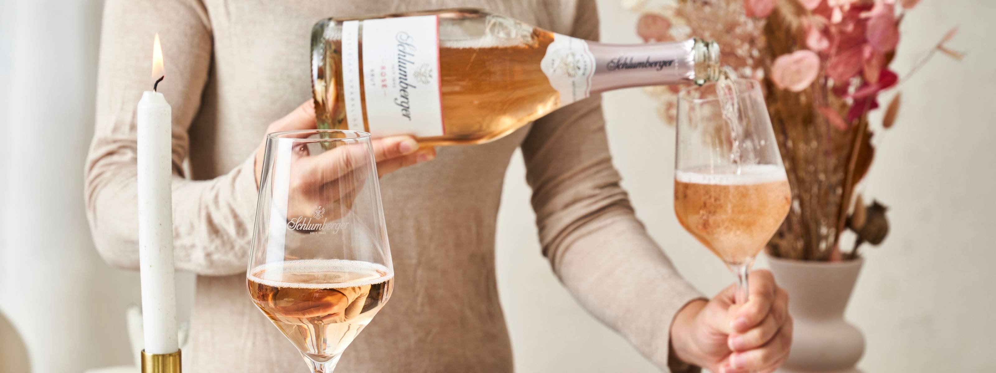 Eine Flasche Rose Brut wird am Tisch eingeschenkt