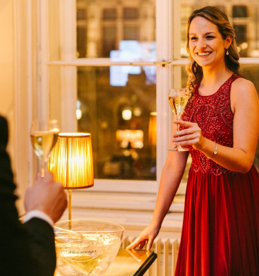 Dame wartet mit Sektglas in der Hand auf ihren Partner