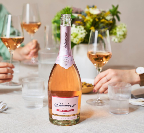 Pinot Noir steht auf einem Tisch Personen stoßen mit gefüllten Gläsern an