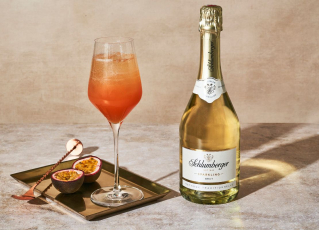 Schlumberger Sektcocktail in Weißweinglas mit einer Flasche Sparkling
