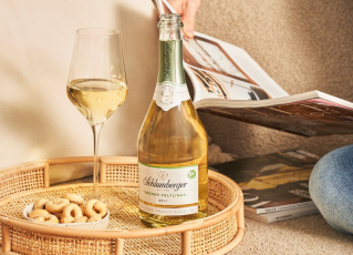 Sektflasche Grüner Veltliner mit Glas auf einem Tablett